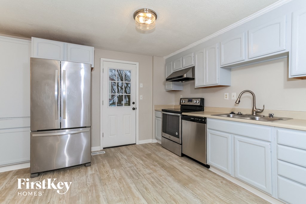 a kitchen with stainless steel appliances and white cabinets