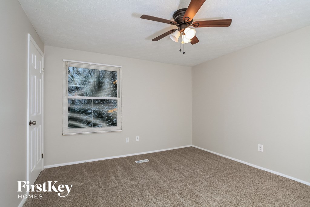 the living room of an empty house with a ceiling fan