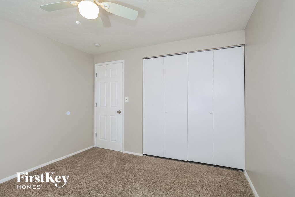 a bedroom with two closets and a ceiling fan