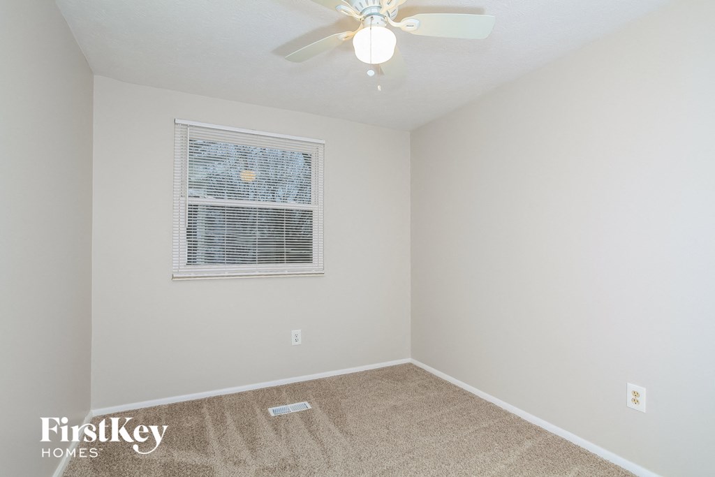 a bedroom with a ceiling fan and a window