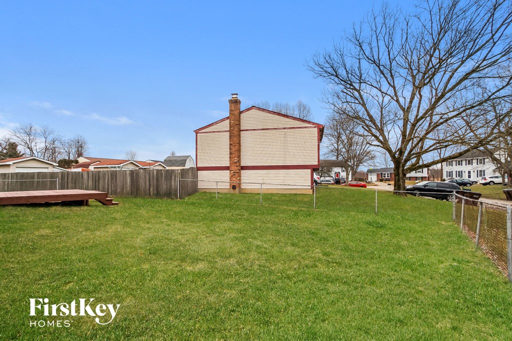 a small house in a fisheye view of a yard and a fence