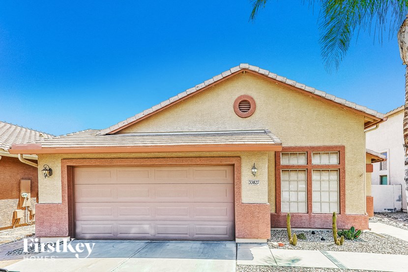 A house with a garage door and a brown roof.