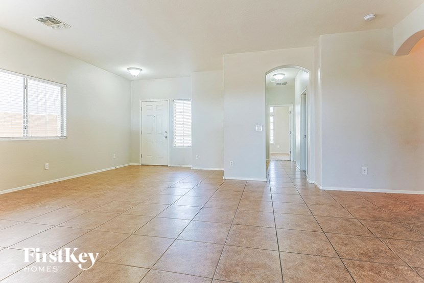 A spacious room with tile flooring and white walls.
