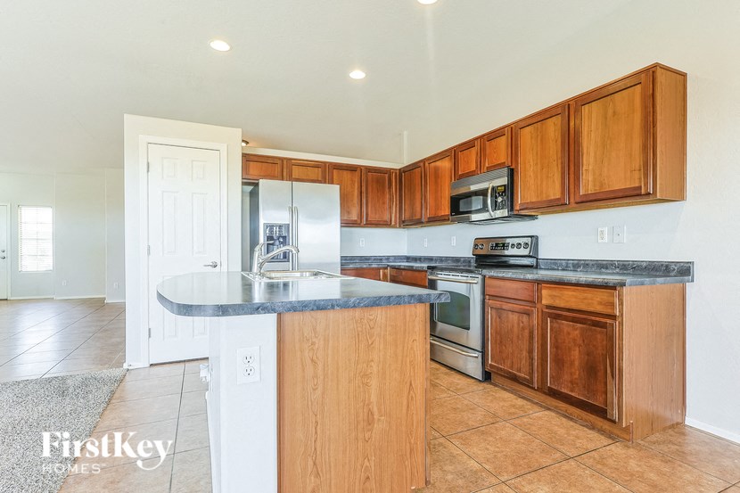 A kitchen with wooden cabinets and a granite countertop.