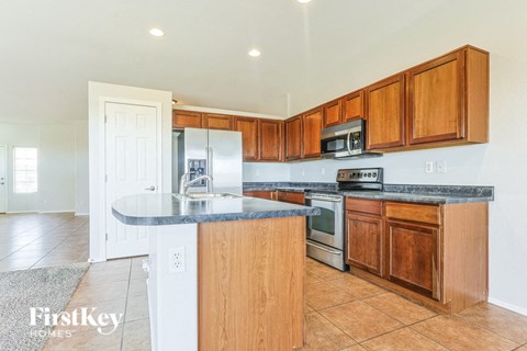 A kitchen with wooden cabinets and a granite countertop.