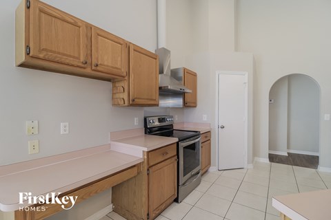 A kitchen with wooden cabinets and a stove top oven.