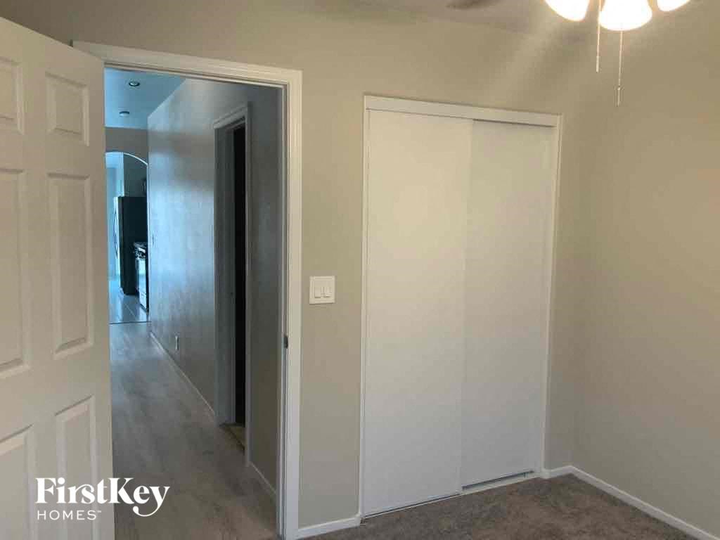an empty room with a door to a hallway and a closet