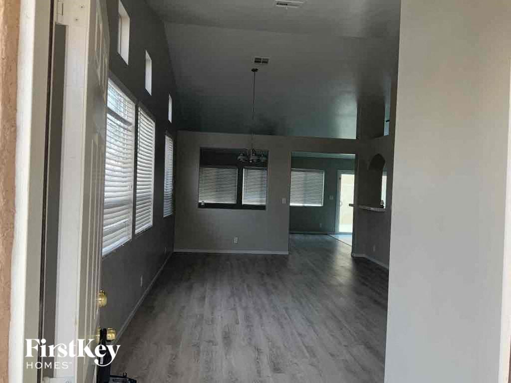 an empty living room with wood floors and windows