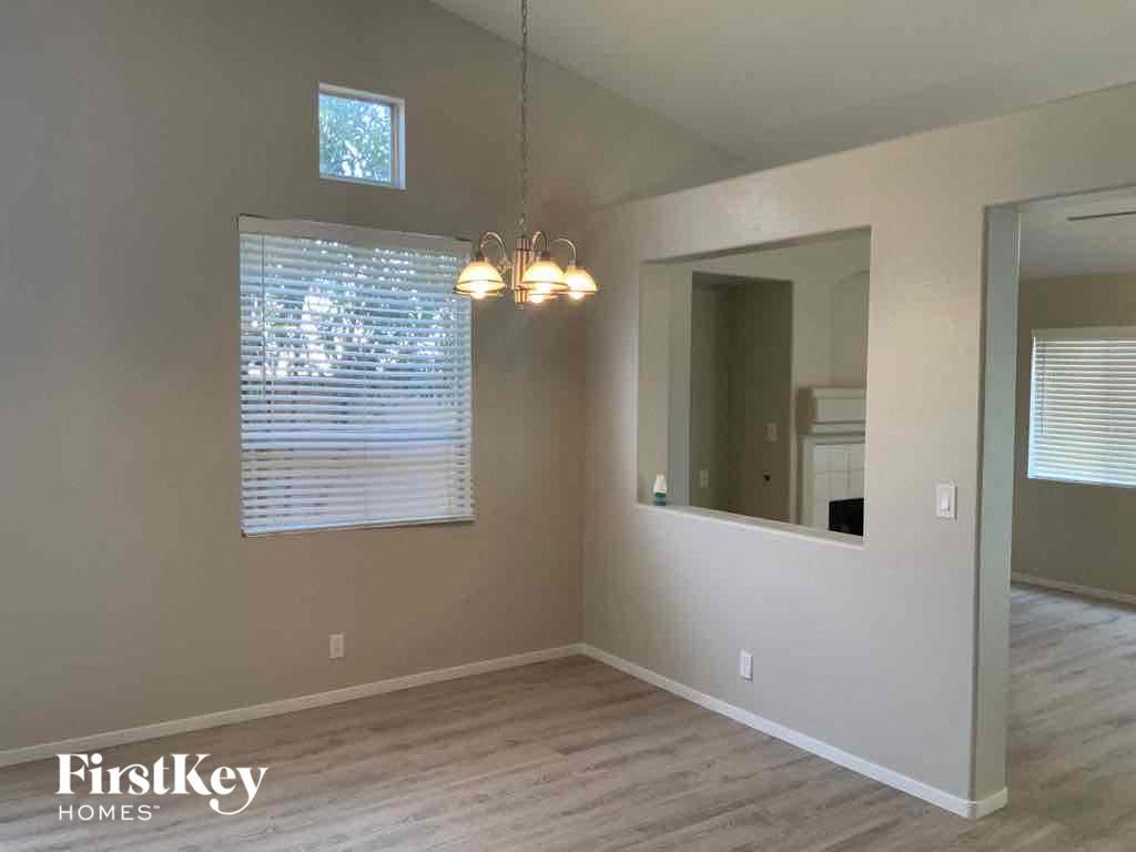 an empty living room with a window and a mirror
