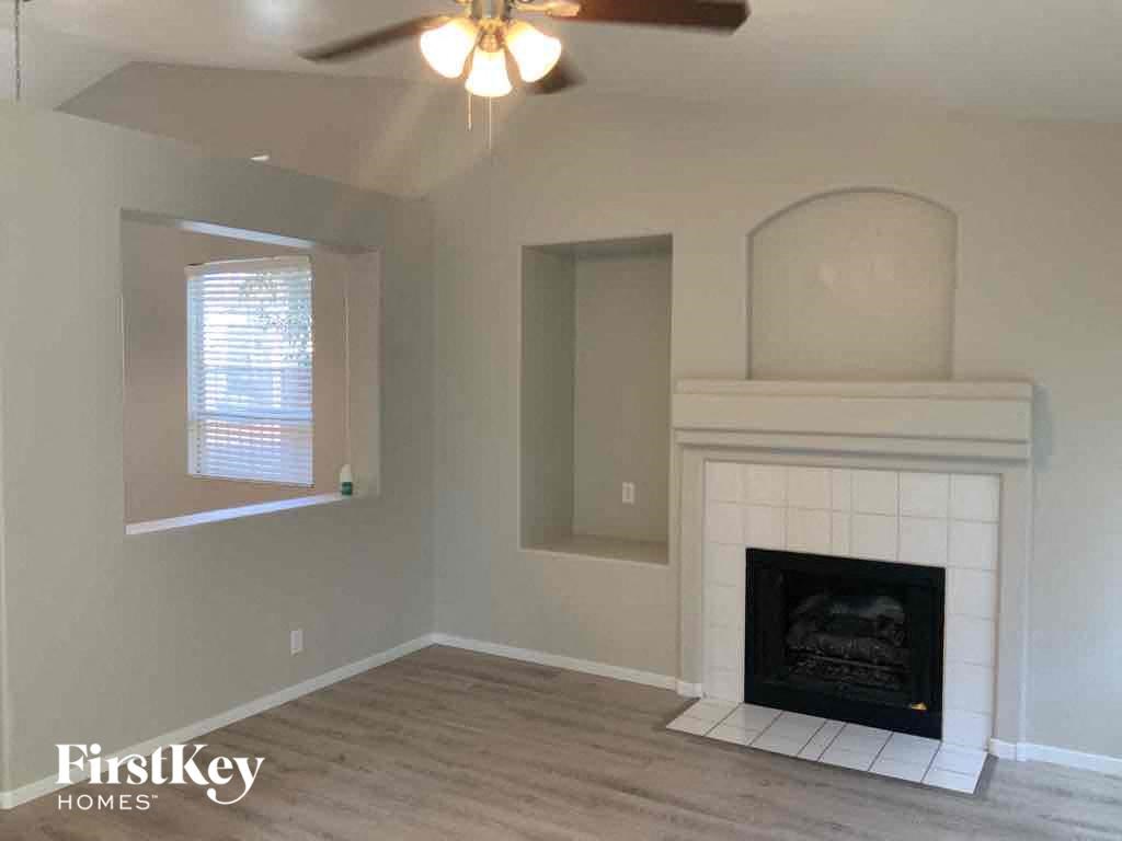 a living room with a fireplace and a ceiling fan