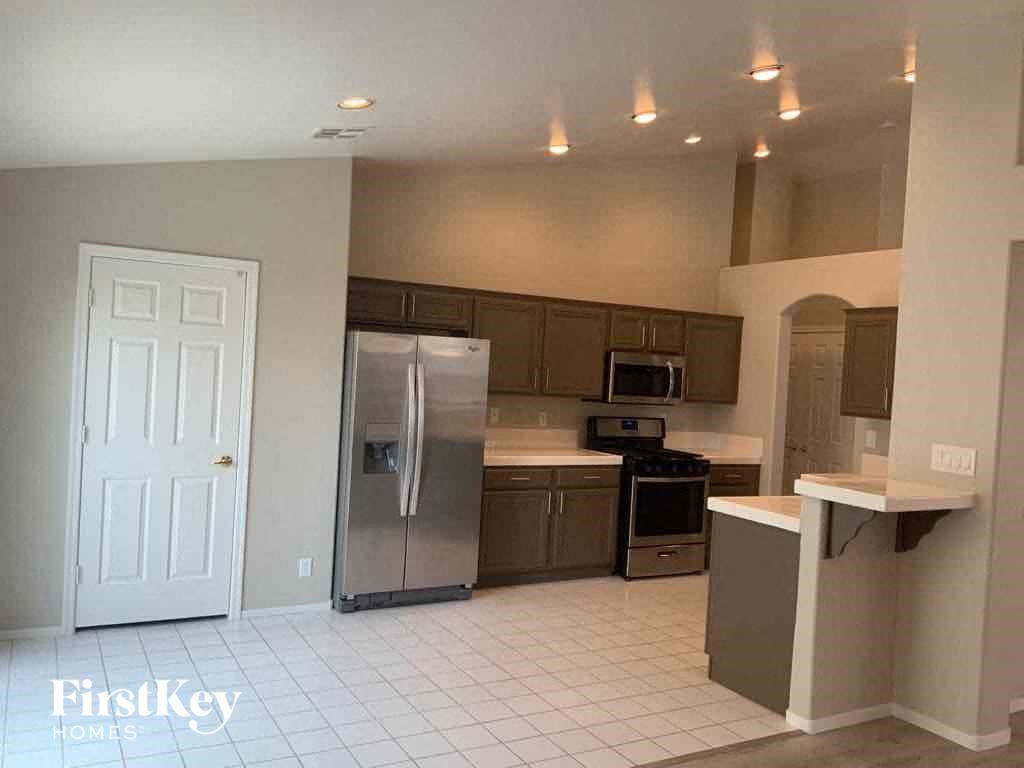 an empty kitchen with a stainless steel refrigerator