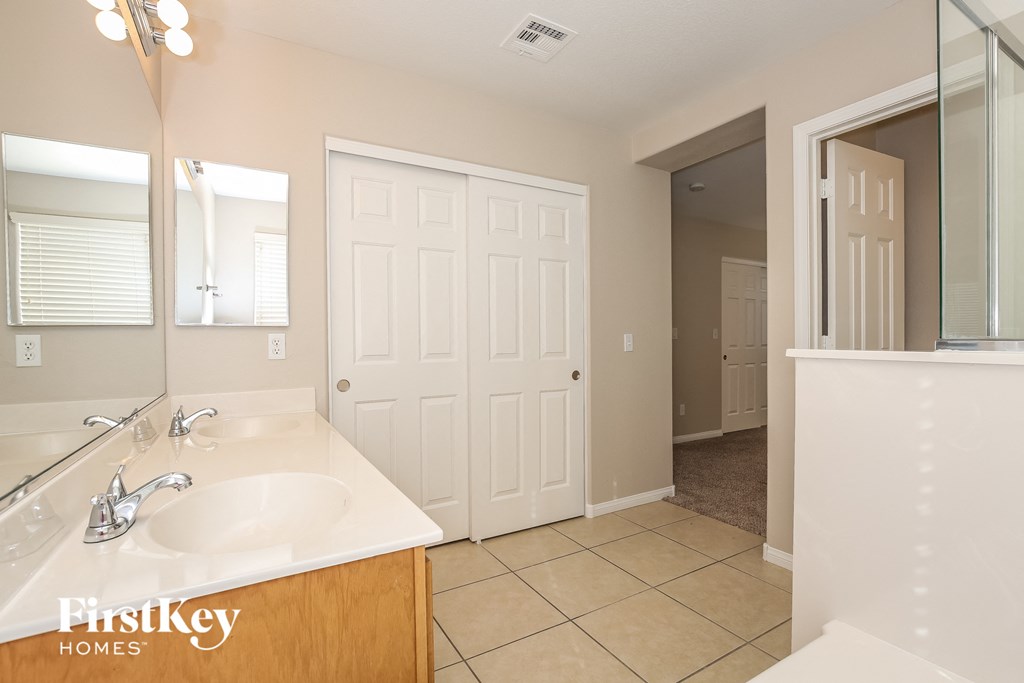 a bathroom with a sink and a mirror and a closet