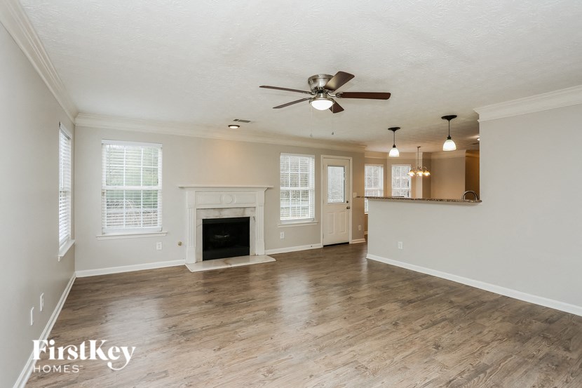 A spacious room with a fireplace and a ceiling fan.