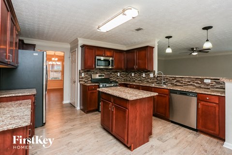 A kitchen with wooden cabinets and a granite countertop.