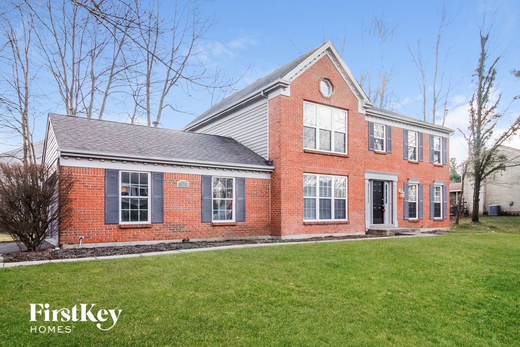 a brick house with a lawn in front of it