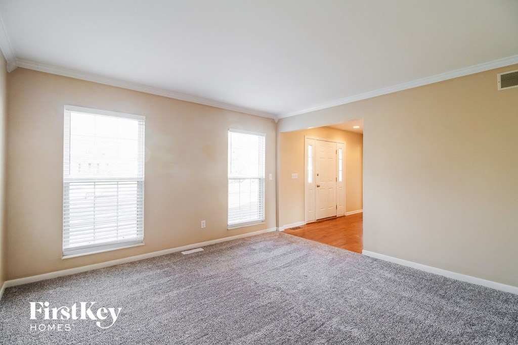 a living room with a rug and two windows