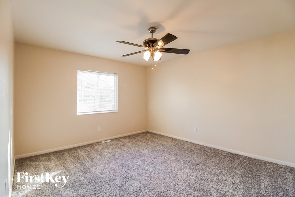 a bedroom with carpet and a ceiling fan