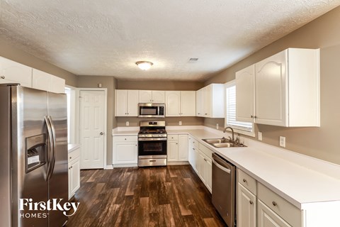 a kitchen with white cabinets and stainless steel appliances