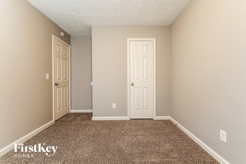 a bedroom with a carpeted floor and two doors