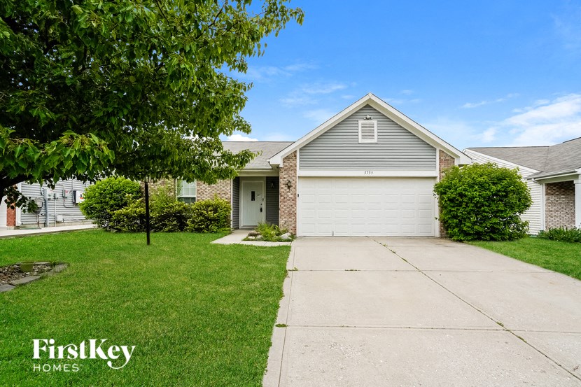 a white house with a driveway and a garage door