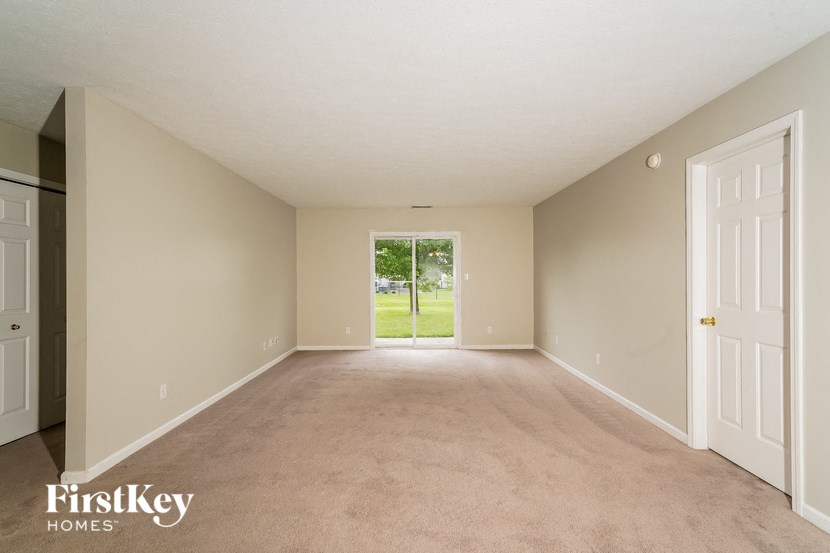 an empty living room with a door to the yard