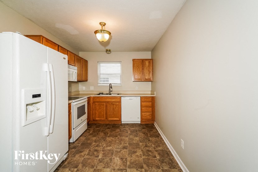 a kitchen with white appliances and wooden cabinets