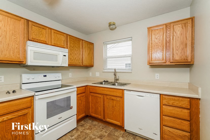 a kitchen with white appliances and wooden cabinets