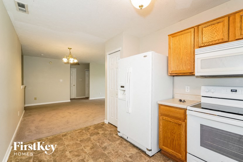 a kitchen with a white stove and a refrigerator