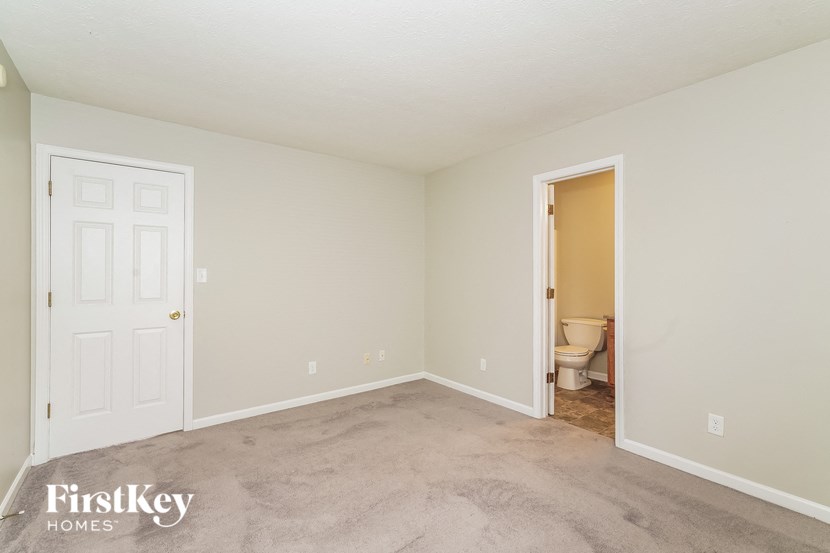 a bedroom with a toilet and a door to a bathroom