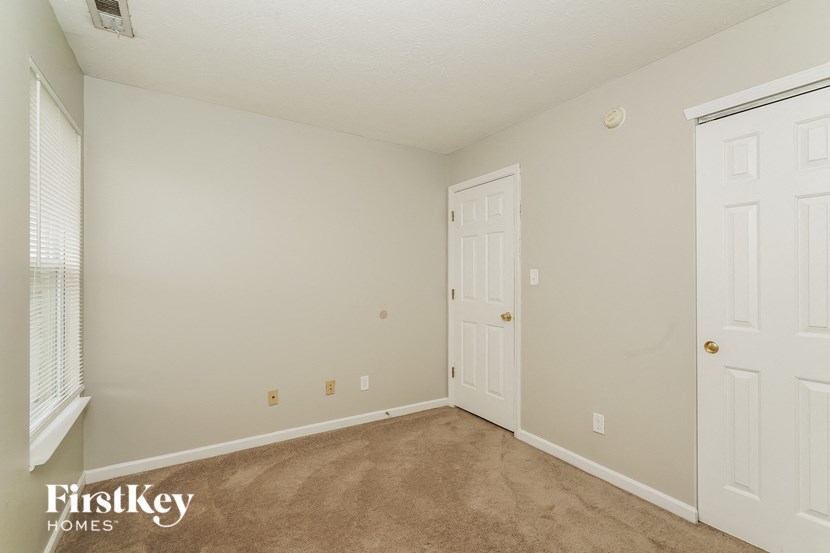 a bedroom with a carpeted floor and white doors
