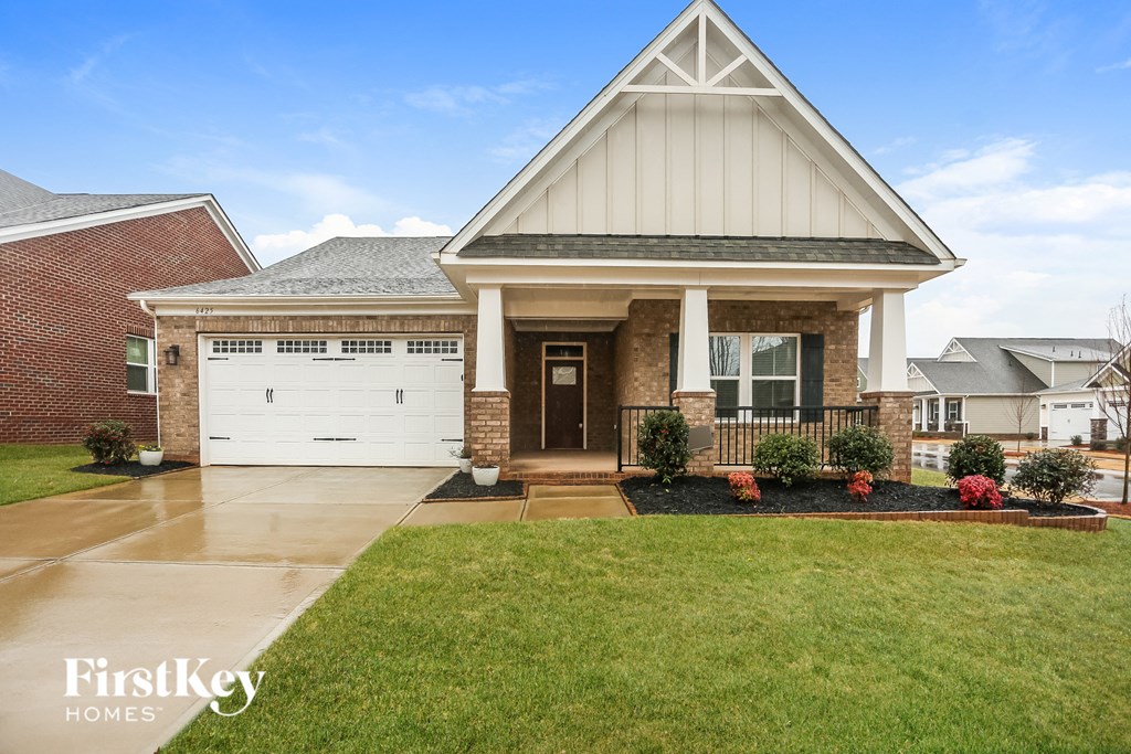A house with a white garage door and a brick wall.