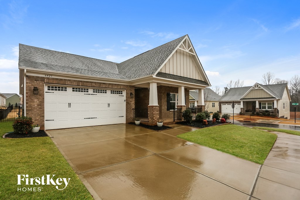 A house with a garage and a driveway in front of it.