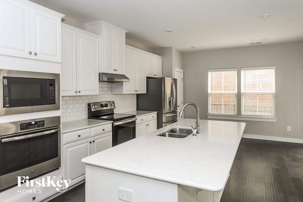 A kitchen with white cabinets and appliances.