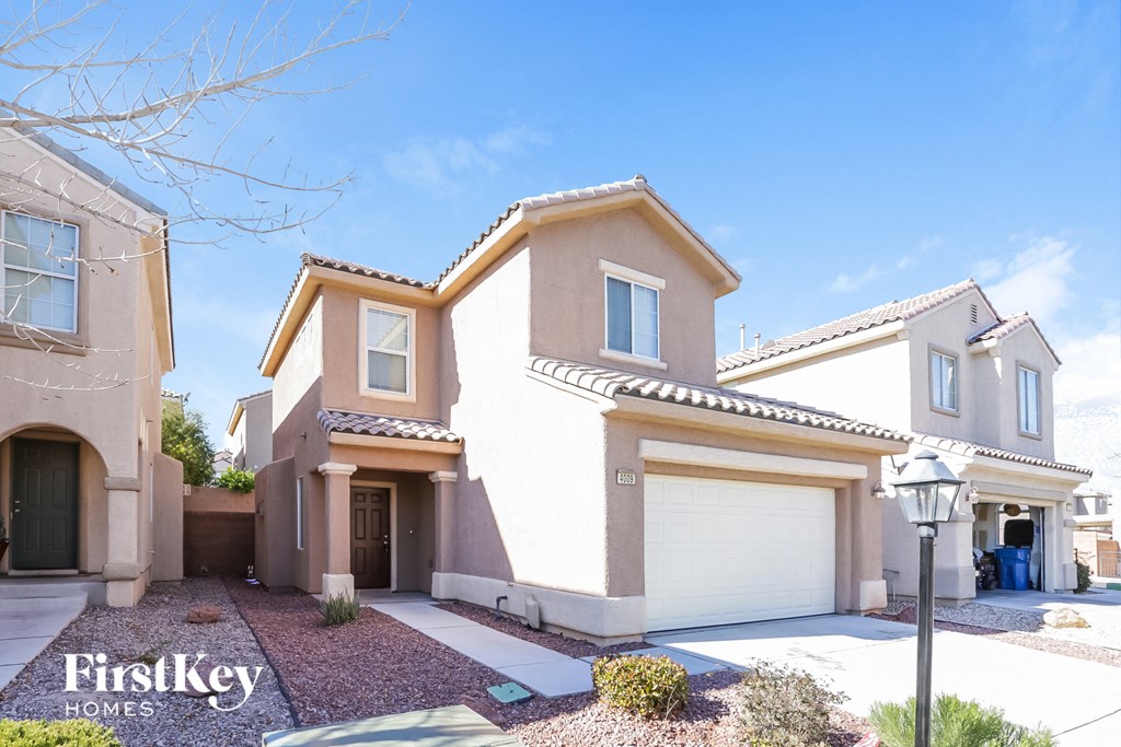 a beige house with a garage door and a street light