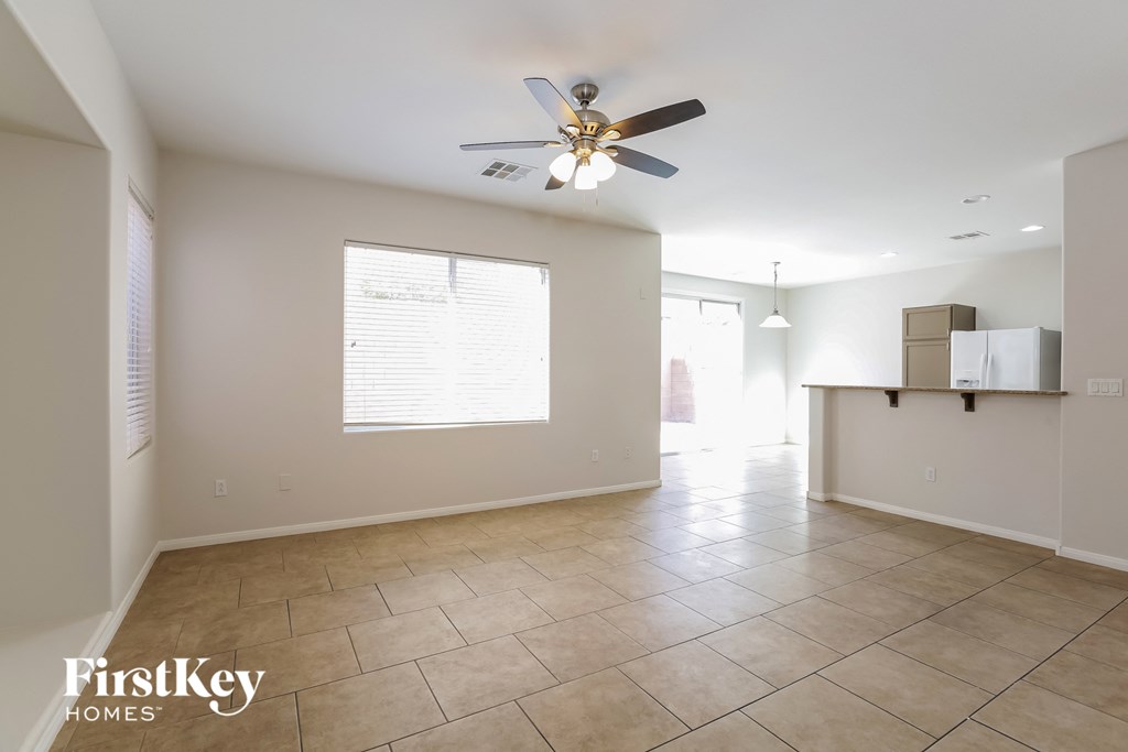 a kitchen and living room with tiled floors and a ceiling fan