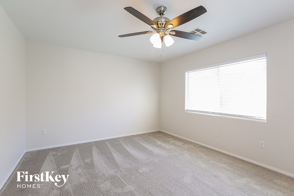a bedroom with a ceiling fan and a window