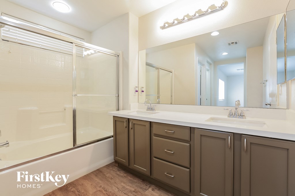 a bathroom with two sinks and a shower and a mirror
