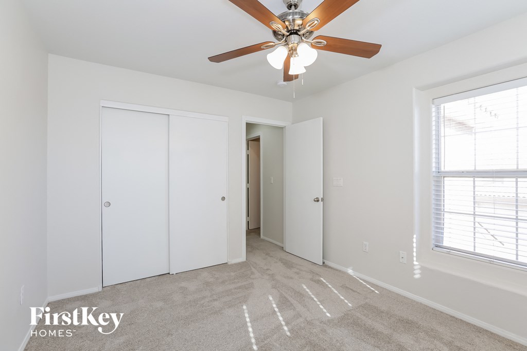 a bedroom with a ceiling fan and a closet