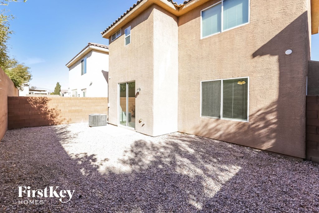 the front yard of a house with gravel and a driveway