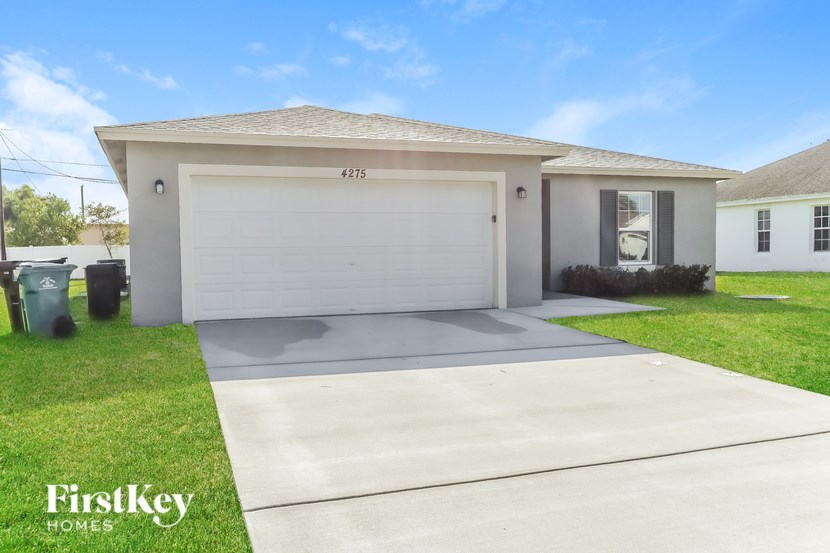 A house with a garage door numbered 215 is for sale.