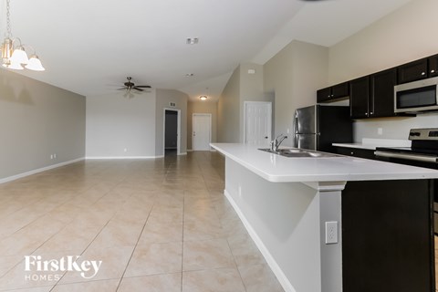 A kitchen with a white countertop and black cabinets.