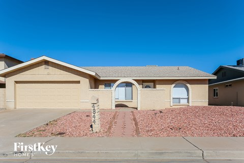 a beige house with a driveway and a garage door