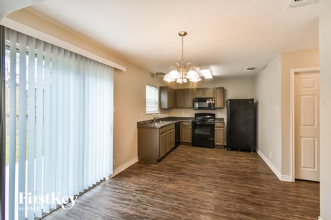 a kitchen with black appliances and a wood flooring and a window