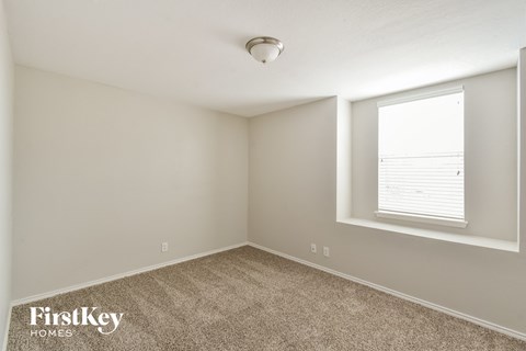 a bedroom with a large window and carpet