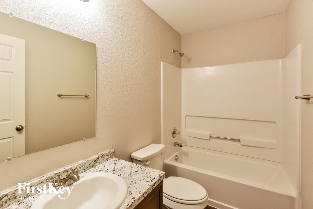 a bathroom with a sink and a toilet and a bath tub