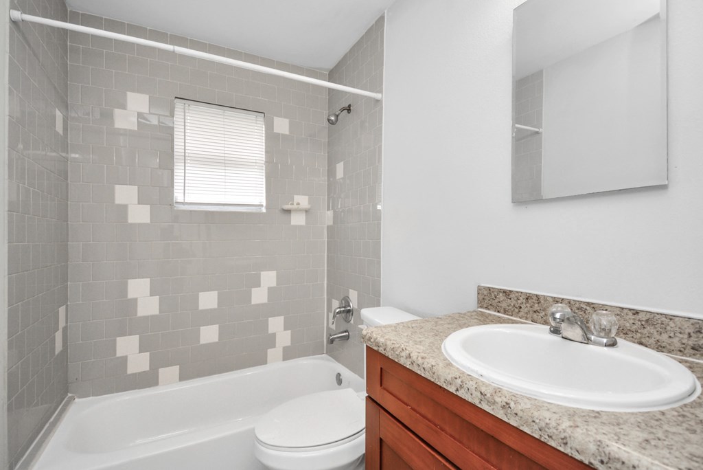 A white toilet sits next to a bathtub in a bathroom.