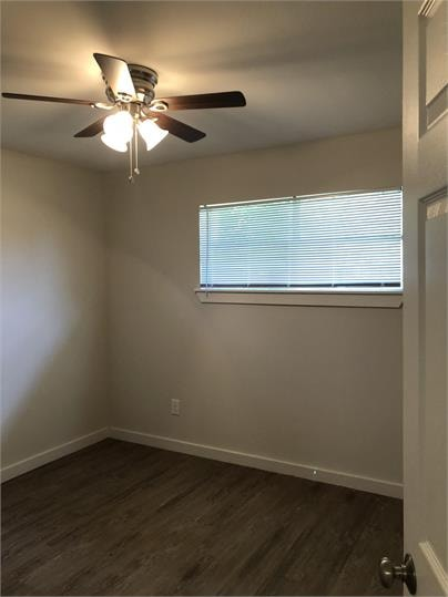 A room with a ceiling fan and a window with blinds.