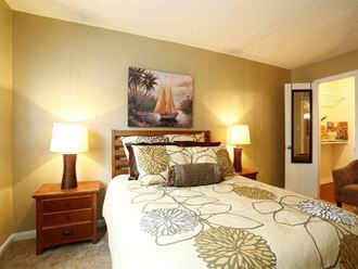 a bedroom with a bed and a painting of a sailboat