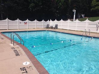 a large swimming pool with a white fence around it