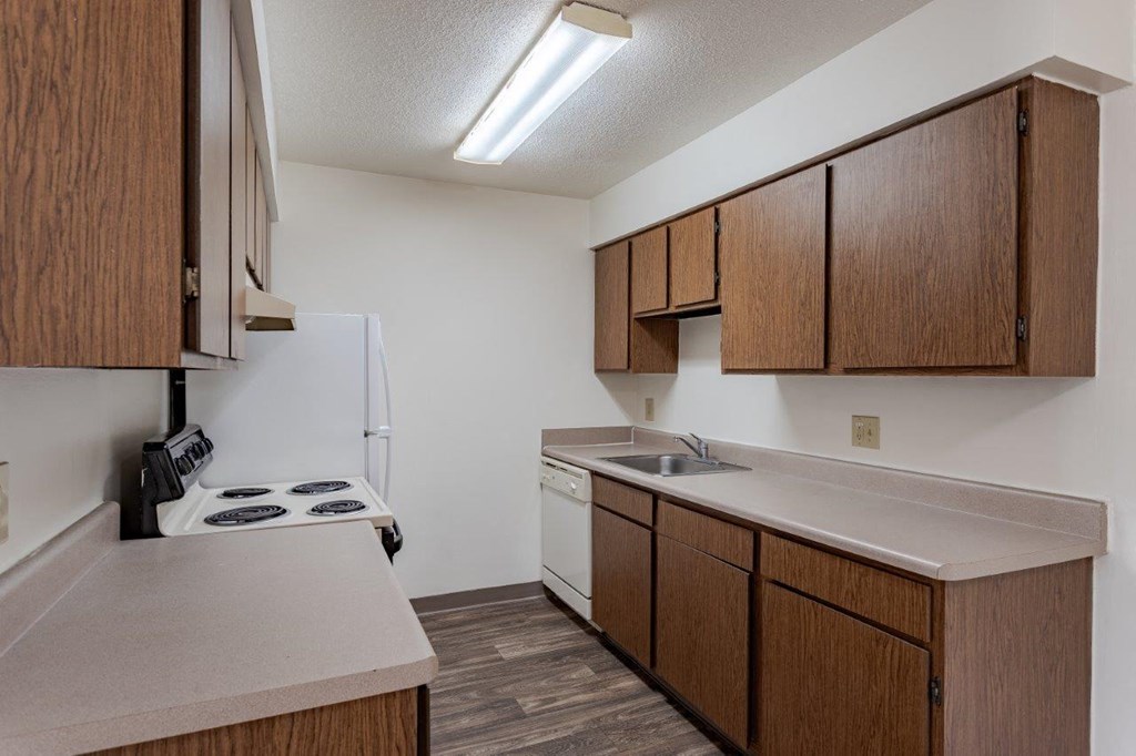 A kitchen with wooden cabinets and a white refrigerator.